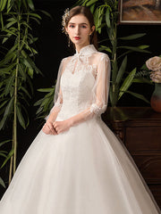 Vestido de novia ajustado con cuello alto y mangas