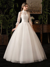 Vestido de novia ajustado con cuello alto y mangas