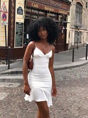 Vestido corto con volantes, espalda descubierta y costuras halter en color liso