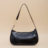 Bolso de un solo hombro color caramelo con diseño de baguette debajo del brazo