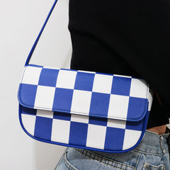 Bolso pequeño cuadrado de rejilla en blanco y negro con un solo hombro debajo del brazo