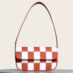 Bolso pequeño cuadrado de rejilla en blanco y negro con un solo hombro debajo del brazo