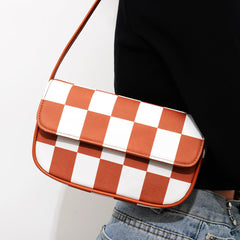 Bolso pequeño cuadrado de rejilla en blanco y negro con un solo hombro debajo del brazo