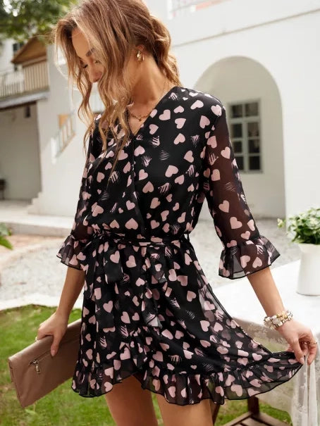 Vestido corto cruzado con volantes y mangas 3/4 con estampado de corazones negros 